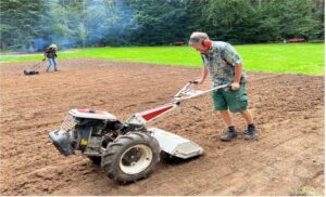Leistungsfähige Vertikutierer werden bei der Anlage der Blumenwiese ausprobiert. Vertikutieren macht den Boden feinkrümelig für die Aussaat